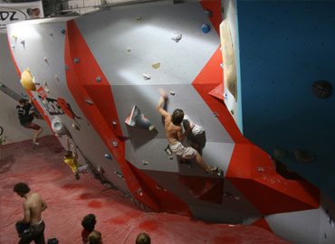 Spectators watch climbers on bouldering wall
