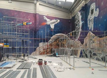 Indoor playground installation with space mural