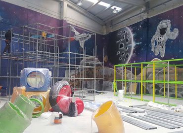 Indoor playground installation with space mural