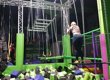 Girl on floating boards at Flip Out ninja warrior training course, Chester, UK