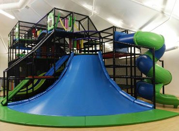 Installed indoor play structure with climbing volcano