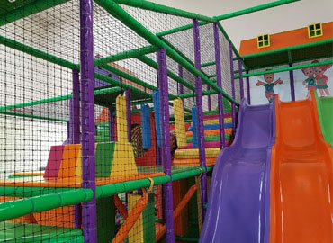 Commercial play structure with wave slide