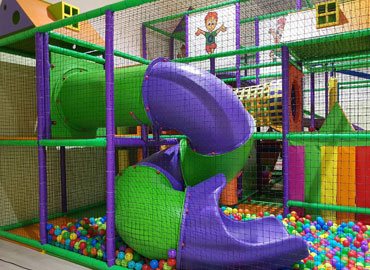Commercial play structure with tube slide and coloured balls