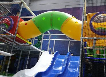 Commercial indoor play structure with tube slide