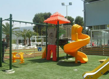Installed outdoor play structure with spiral slide and swings